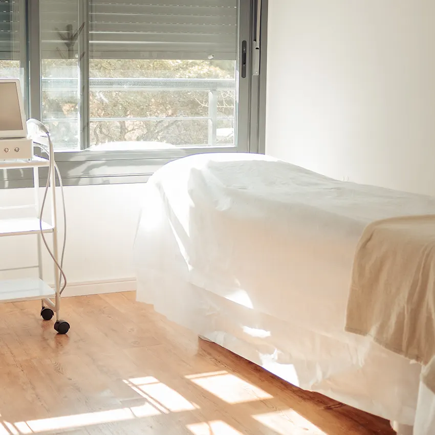 camailla vacía con sábanas blancas en apartamento iluminado por el sol